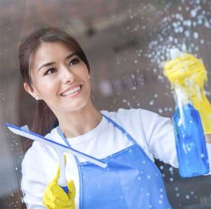 lady cleaning window with cleaning spray