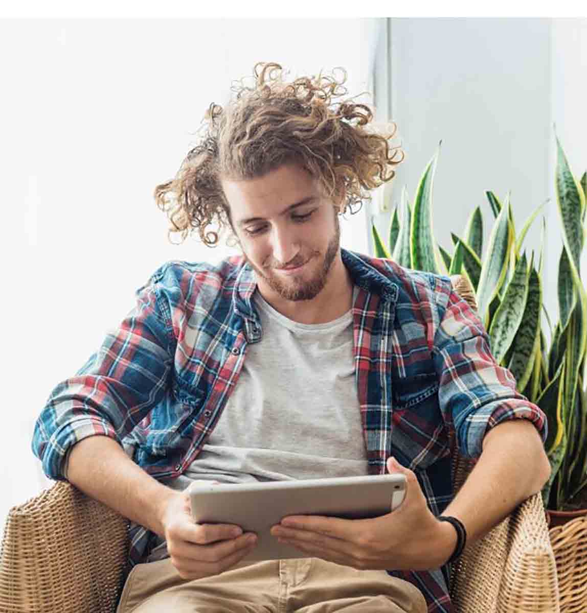 relaxed young man using a tablet whilst taking his Safetyman Academy course