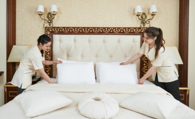 2 female housekeepers preparing the bed in a hotel