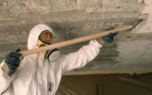 Asbestos Safety in Construction. A worker removing asbestos from an internal roof