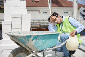 hot employee working with a wheel barrow on a construction site