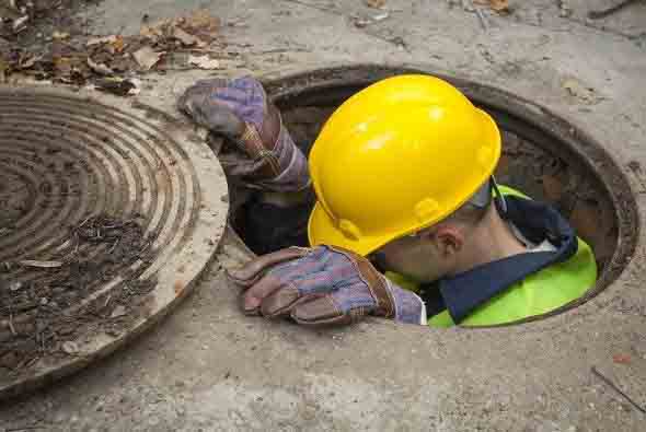 Confined Space Safety in Construction OSHA's 29 CFR 1926 Standards for a Safer Worksite construction worker climbing out of a manhole