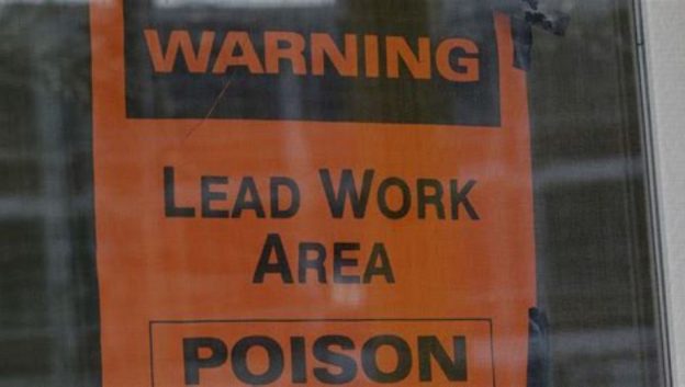 lead warning sign posted onto an entrance door at a property