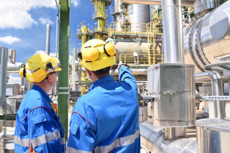 2 chemical workers performing an inspection in a chemical processing plant