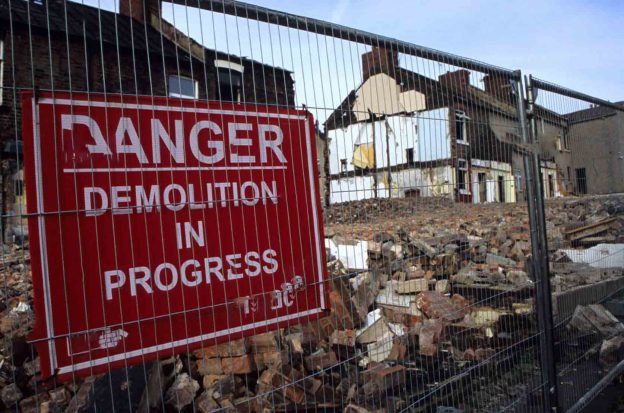 demolition warning signs on a fence