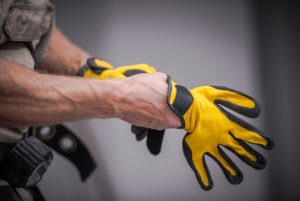 worker pulling on a pair of gloves for work