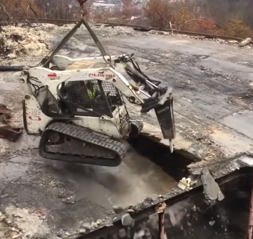 a suspended bobcat used to break a concrete floor