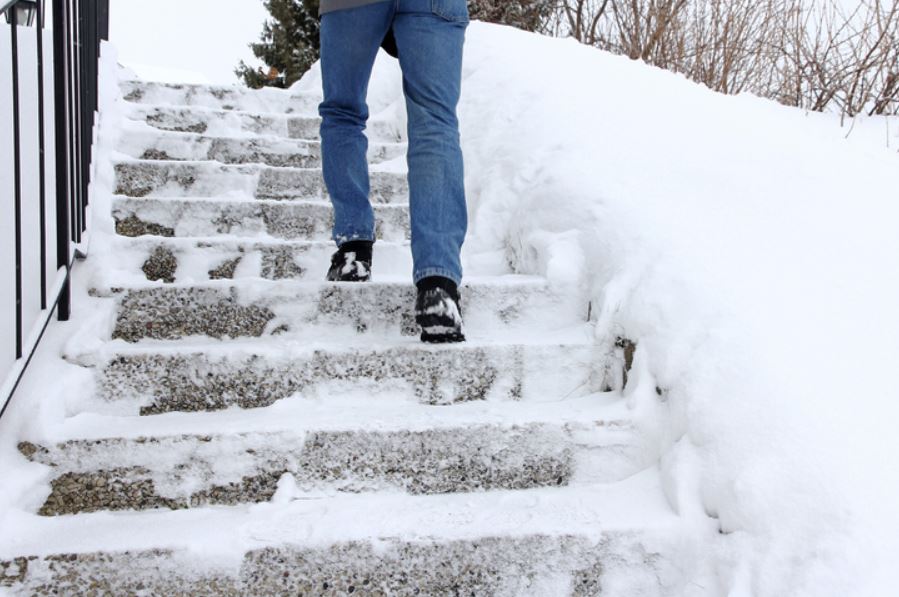 man walking down icy steps without using the handrail