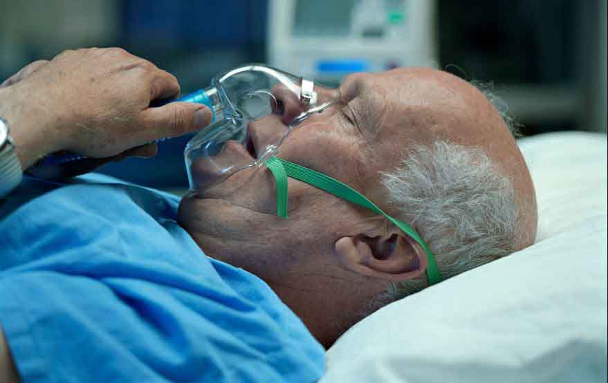 a man laying in bed with an oxygen mask on his face