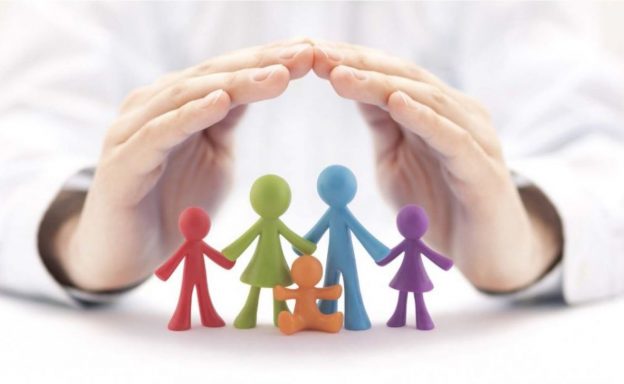 a pair of protective hands over figurines depicting a family