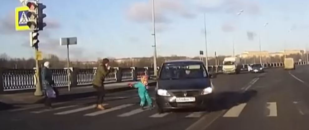 car narrowly misses a child on a crossing