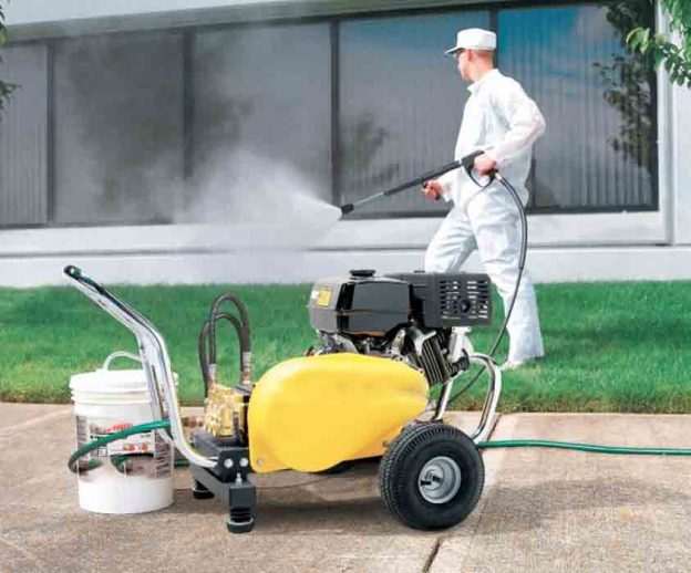 a man pressure cleaning a building