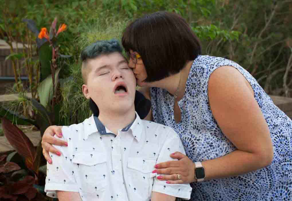 a carer kiss a young man in her care